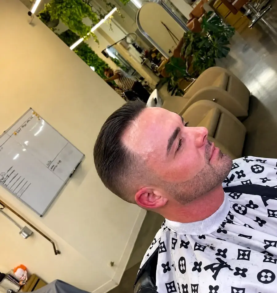 Executive slick-back taper fade with beard blend on straight hair by Hollywood barber Michael Fields