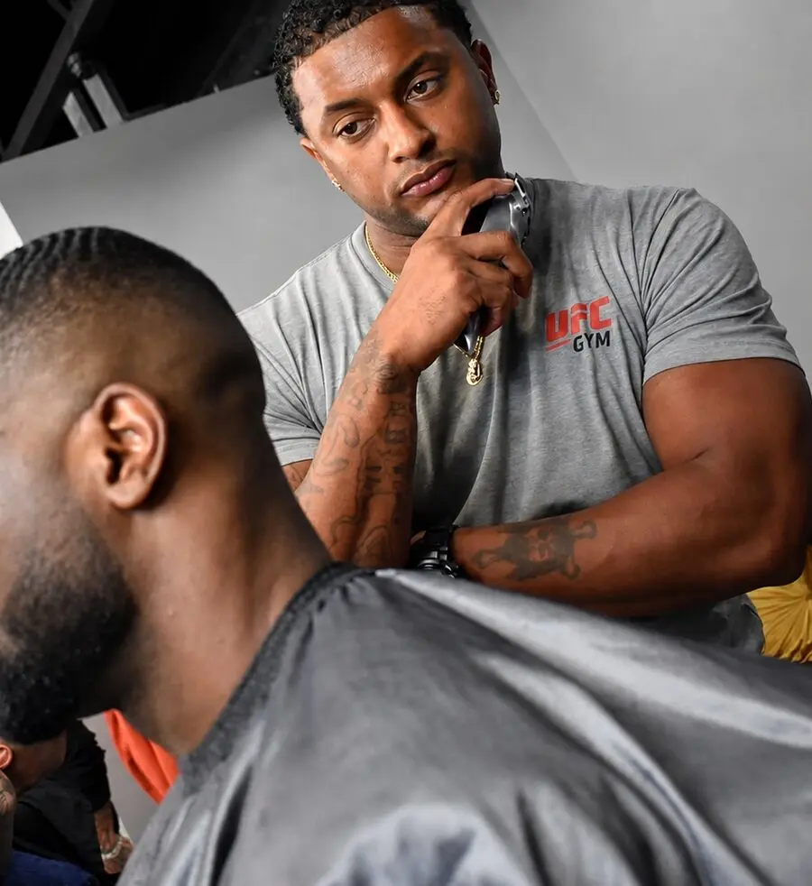 Master barber Michael Fields of The Best Cuts cutting a client's fade with clippers on Hollywood Blvd, Los Angeles